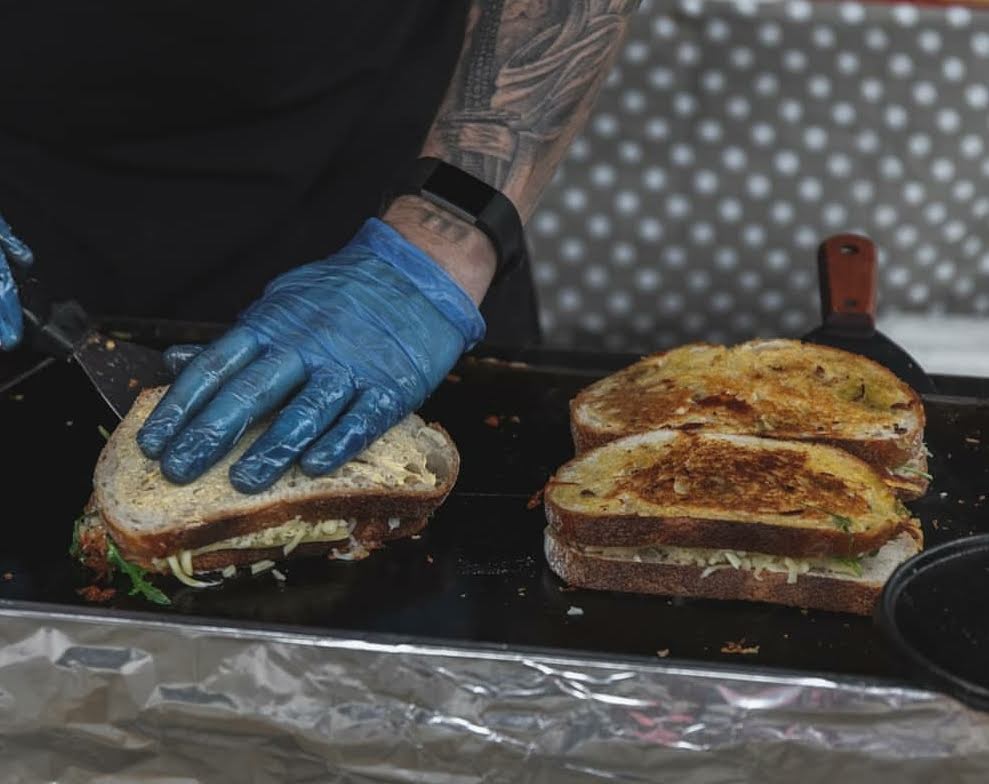 Cook working on the grill making sandwiches